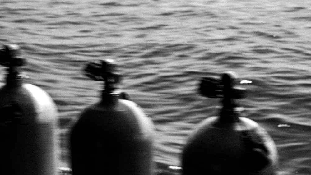 Two scuba tanks blurred against moving water, Koh Tao, Thailand